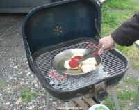 Frying chicken thighs on a barbecue