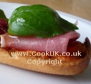 Tomato bread topped with ham and basil