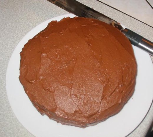 Apply chocolate icing to chocolate cake