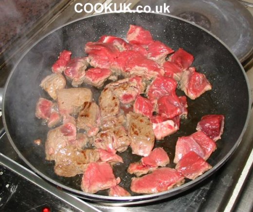 Beef cubes browning in a frying pan